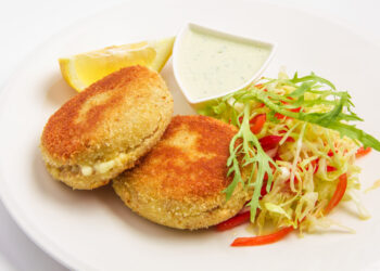 fishcakes sauce, lemon, lettuce. On white background
